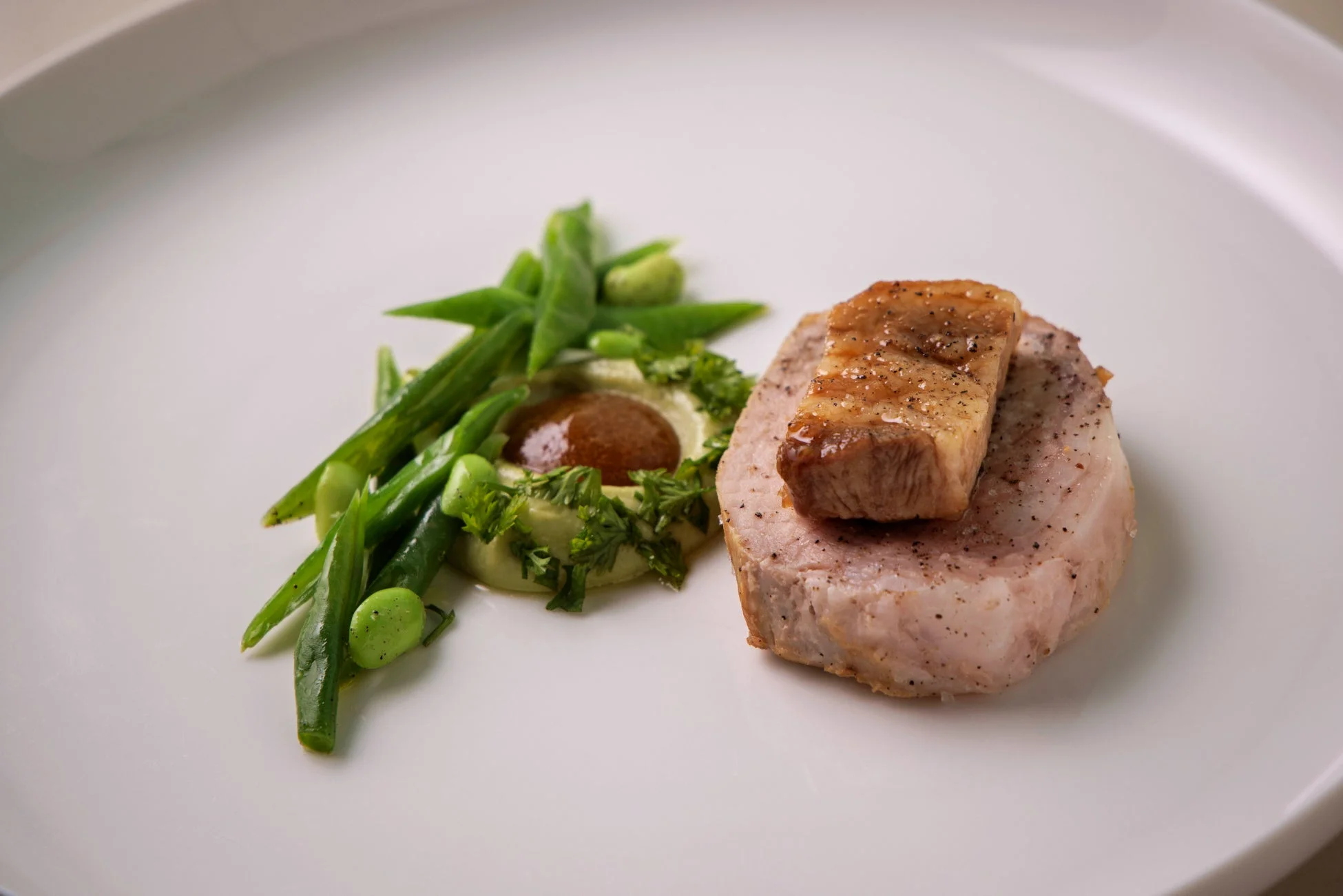 白い皿に盛り付けられた肉料理