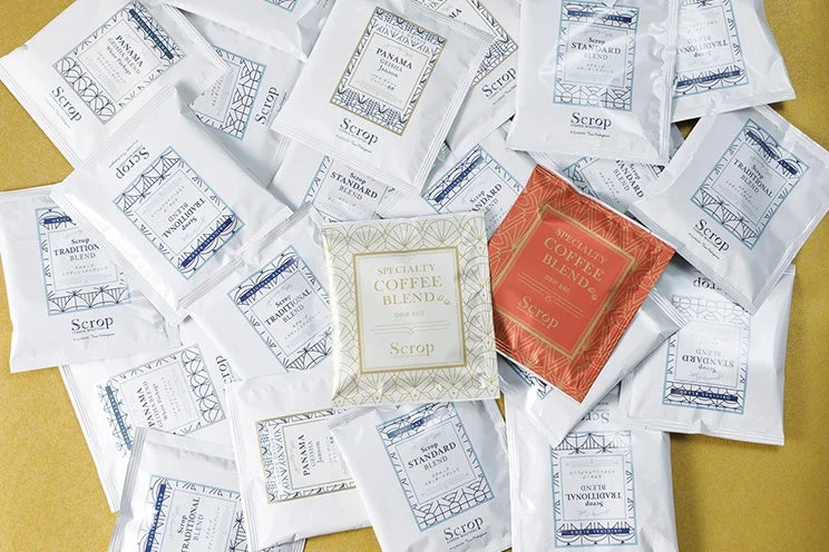 「Scrop」ブランドの様々な種類のドリップバッグコーヒーが多数散りばめられた画像です。パナマゲイシャ、トラディションブレンド、スタンダードブレンド、スペシャルティコーヒーブレンドなどがあり、主に白を基調としたパッケージデザインが特徴です。