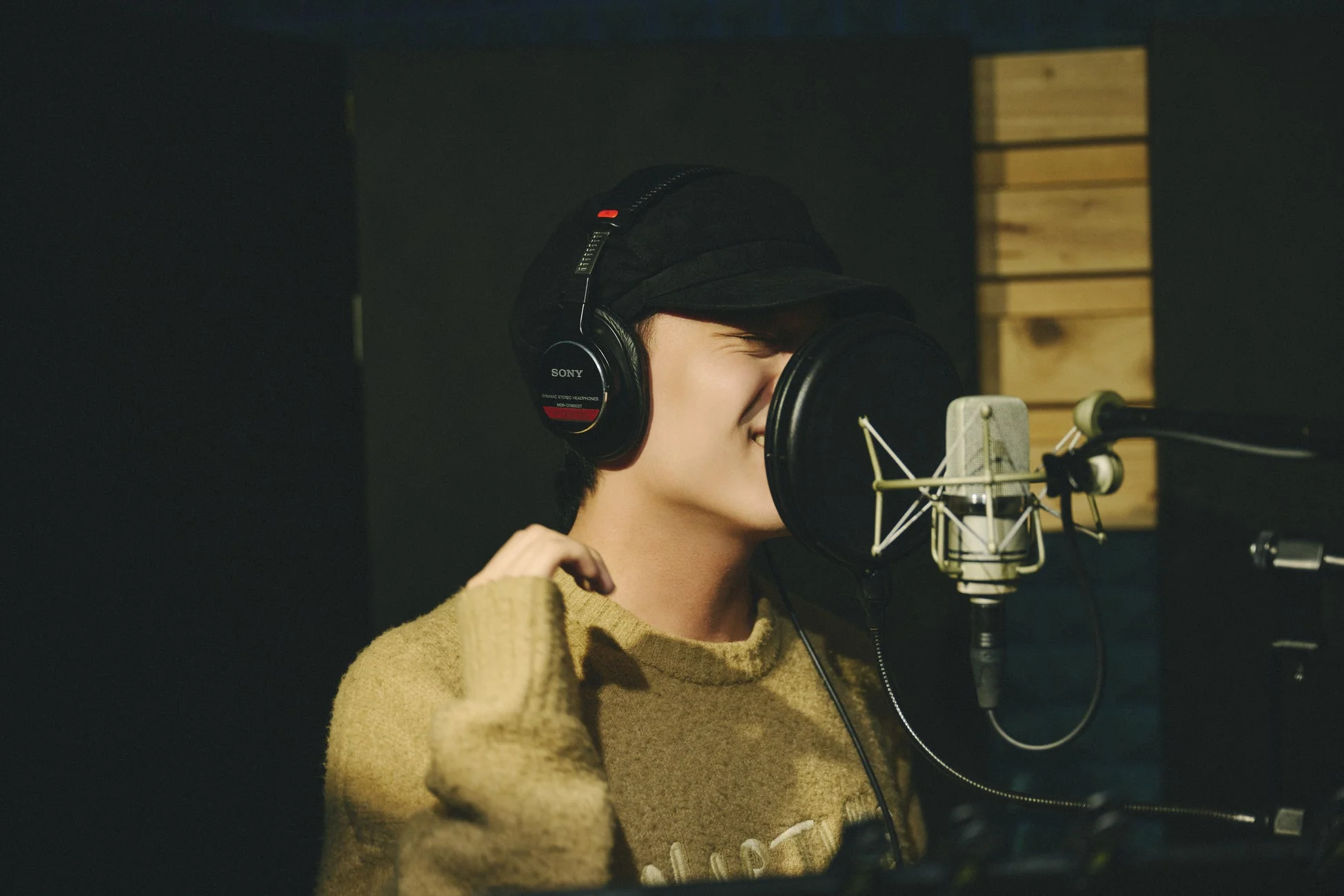 ヘッドホンを装着しマイクに向かう人物