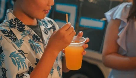 海藻由来ストローで飲み物を飲む子供