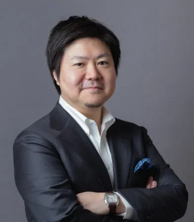 ダークスーツを着用し、腕を組んでカメラを見つめるアジア人男性のビジネスポートレート