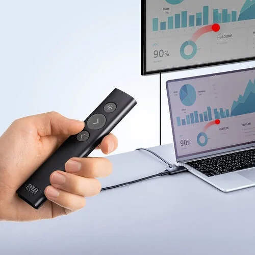 手がプレゼンターを持ち、ノートパソコンと外部モニターに表示されたプレゼンテーションを操作している様子