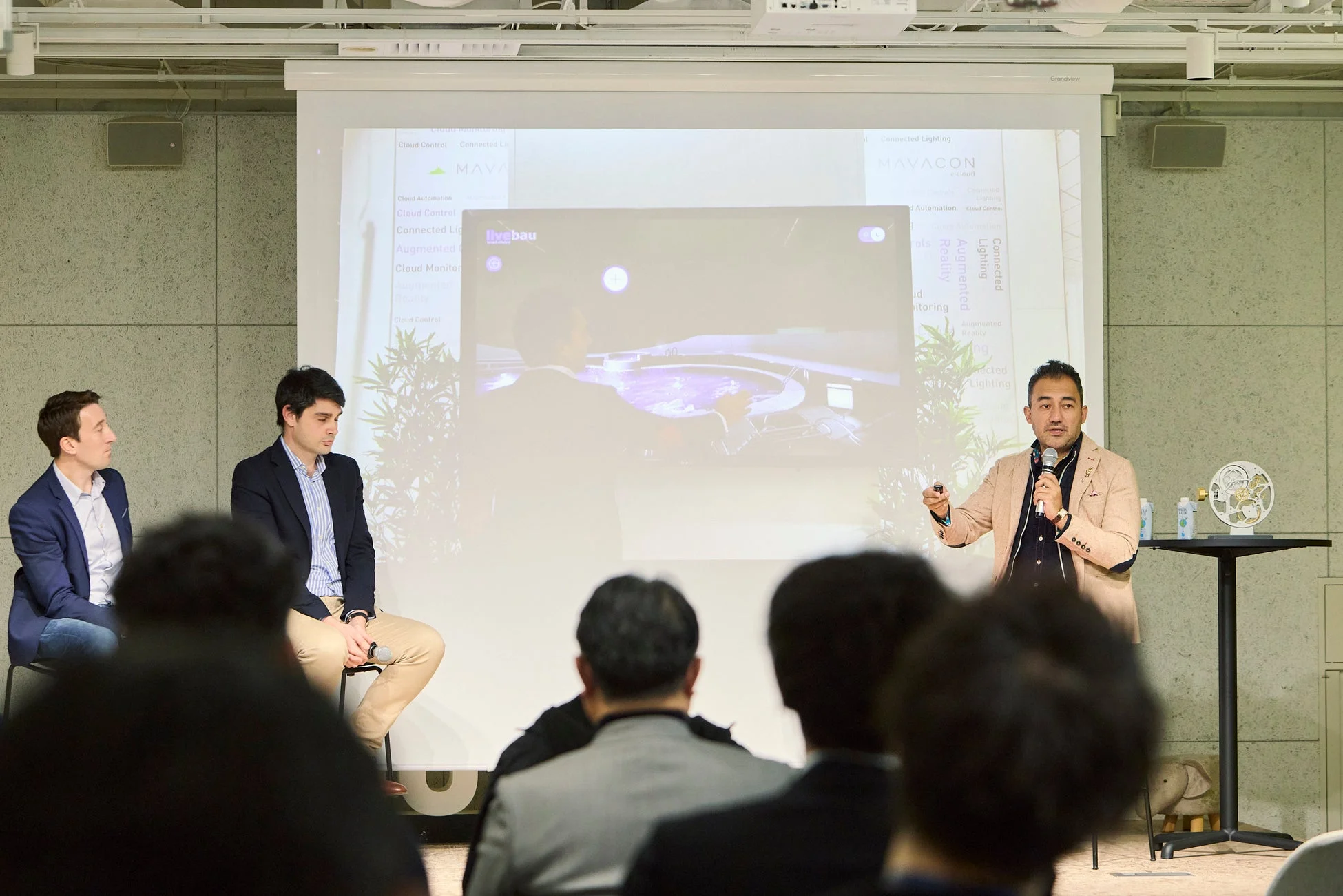 ビジネスイベントで男性がマイクを持ってプレゼンテーション