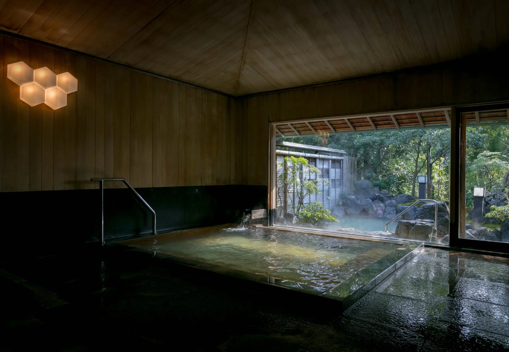 室内から緑豊かな日本庭園を望む温泉