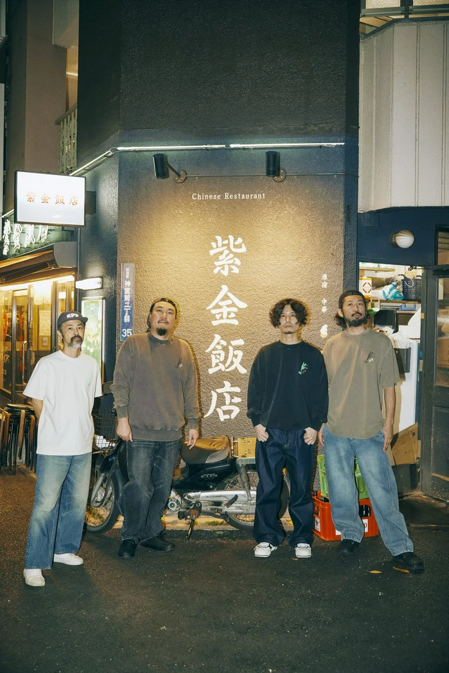 紫金飯店前でコラボアイテムを着用するグループ