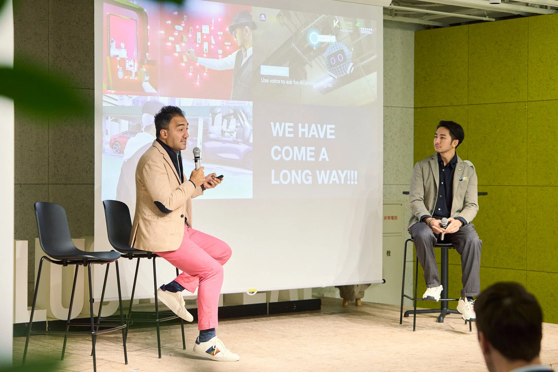 ステージ上でプレゼンテーションを行う2人の男性