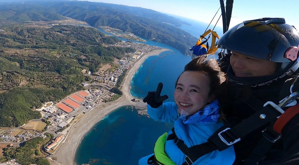 パラグライダー,スカイダイビング,空,海,ビーチ,山,景色,絶景,笑顔,冒険,スポーツ,レジャー,旅行,空撮,高所,タンデム飛行