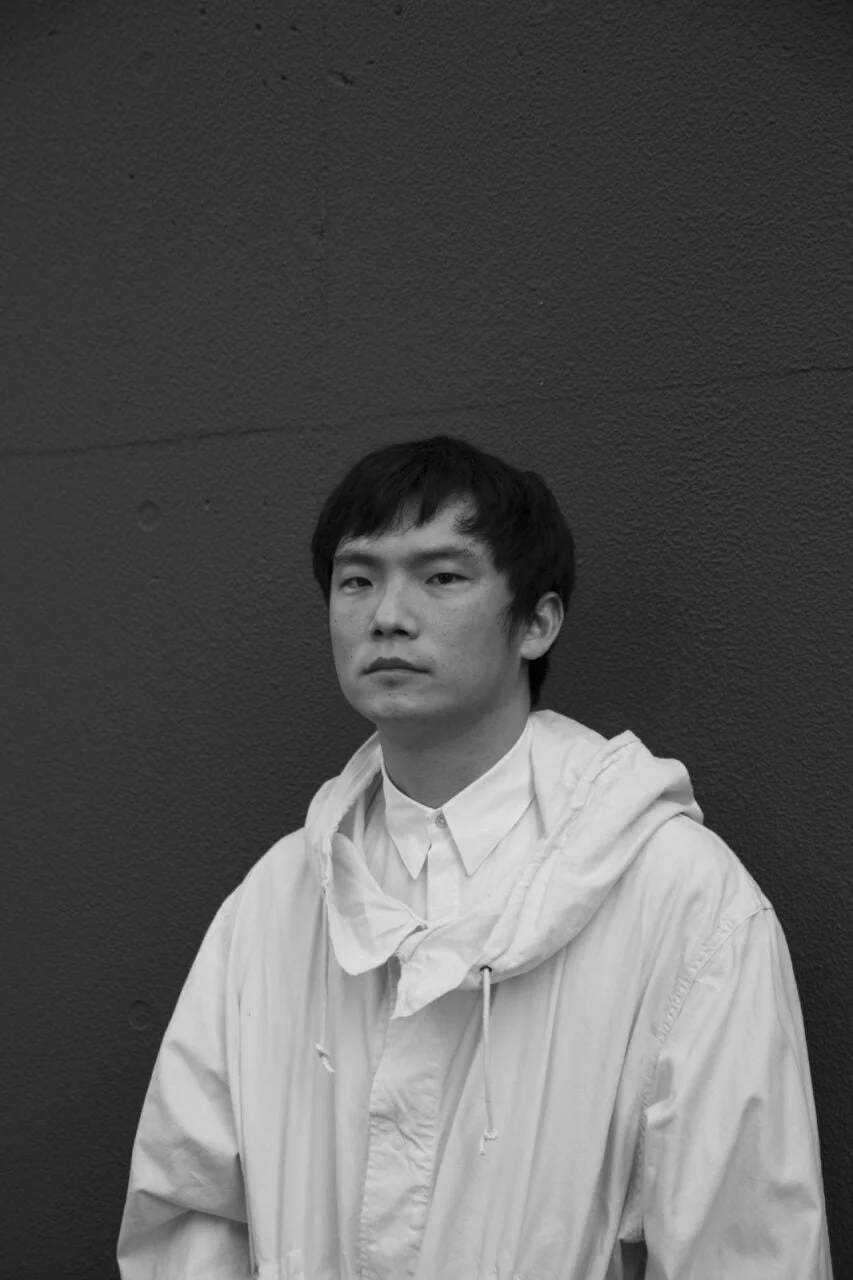 白いフード付きジャケットを着た男性の白黒ポートレート