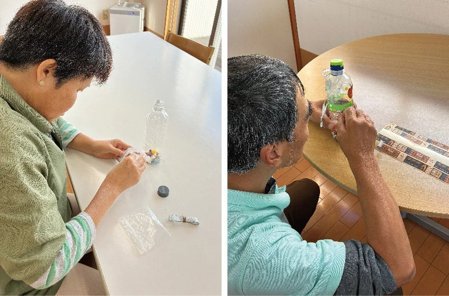 テーブルでプラスチックボトルを使った手芸活動に取り組む人たち