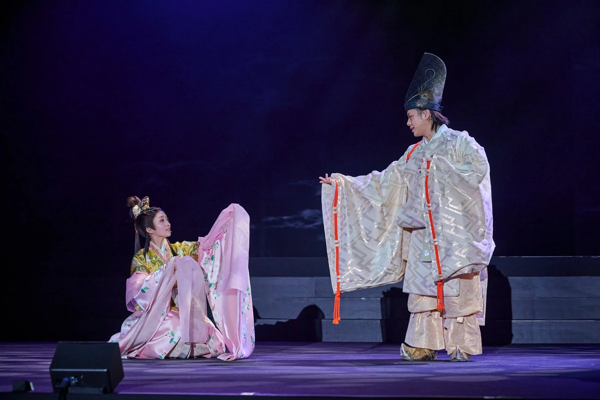 豪華な伝統衣装の二人の演者、跪く