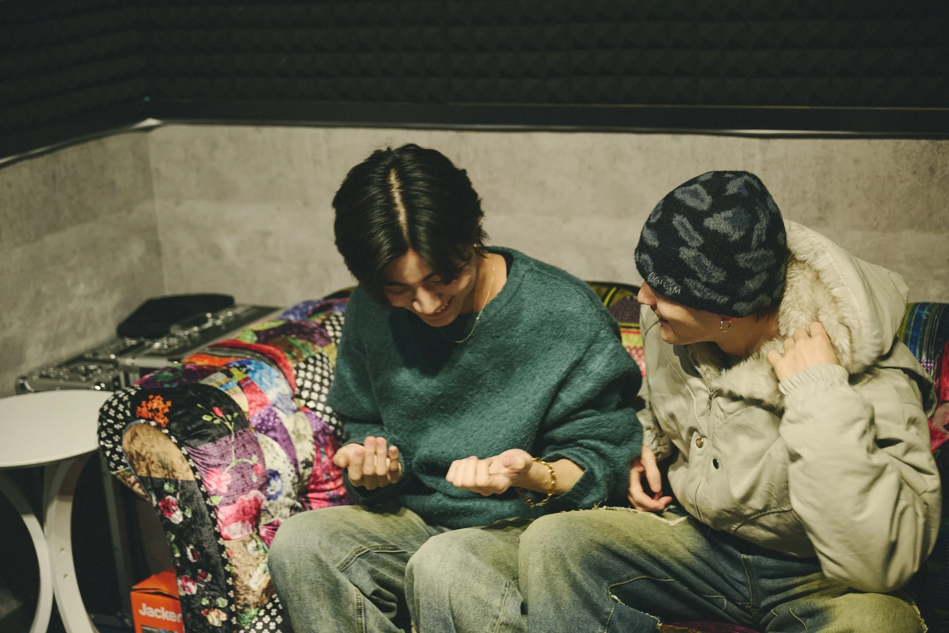 ソファで笑顔で談笑する二人の男性