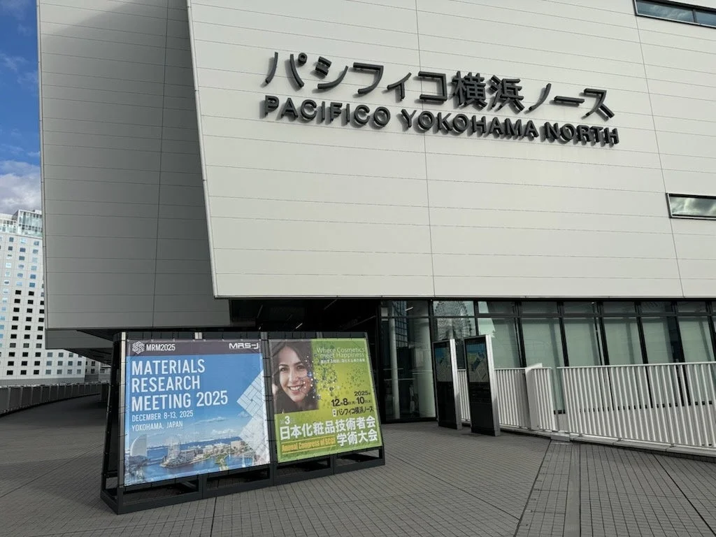 パシフィコ横浜ノースの建物外観と、材料研究と化粧品技術に関する国際会議や学術大会の告知看板