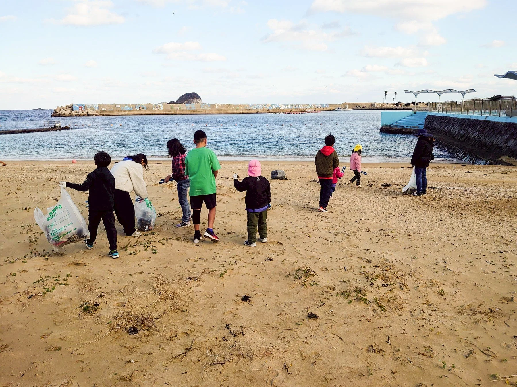 子どもたちがビーチでゴミ拾いをする様子