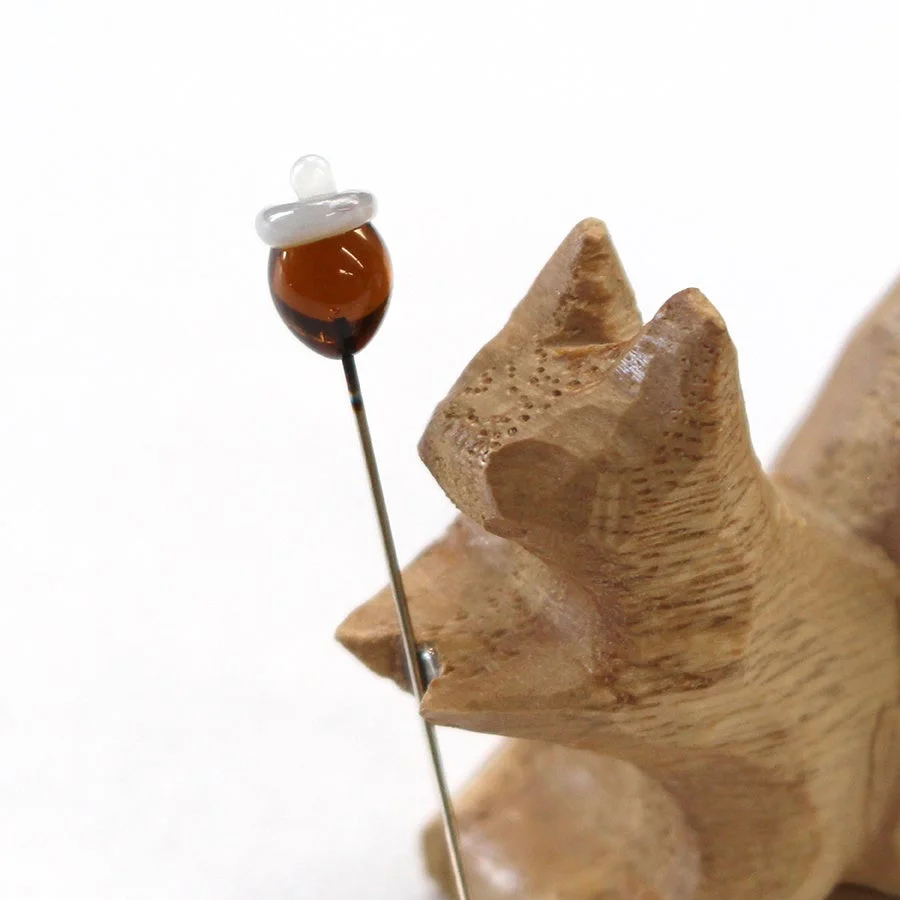 コリスがどんぐりの待針を抱えている様子