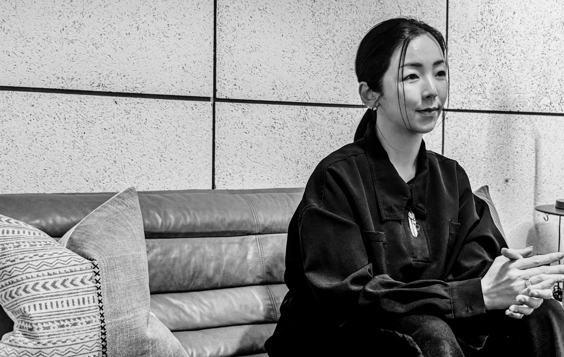 ソファに座って話を聞いている様子の女性の白黒写真