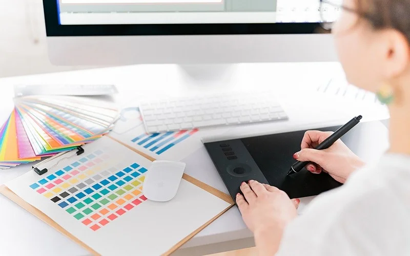 ペンタブレットとパソコンを使ってデザイン作業をする女性の手元