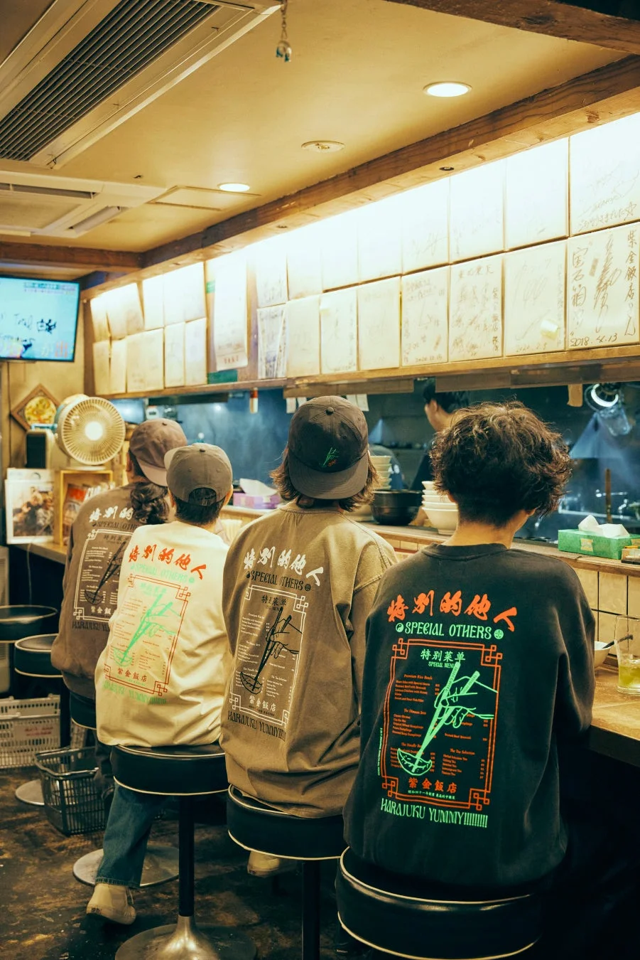 ラーメン屋でコラボアイテムを着用する人々