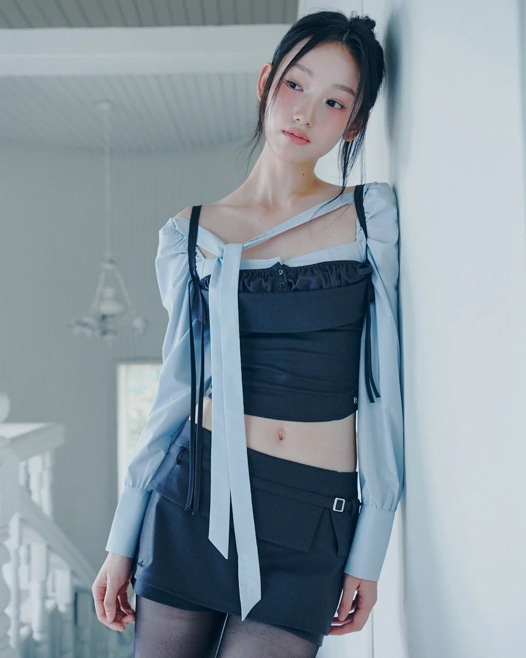 白い壁に寄りかかる若い女性のポートレート