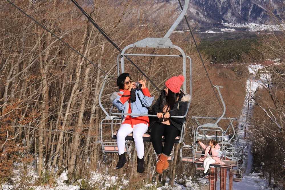 チェアリフトに乗る女性たち