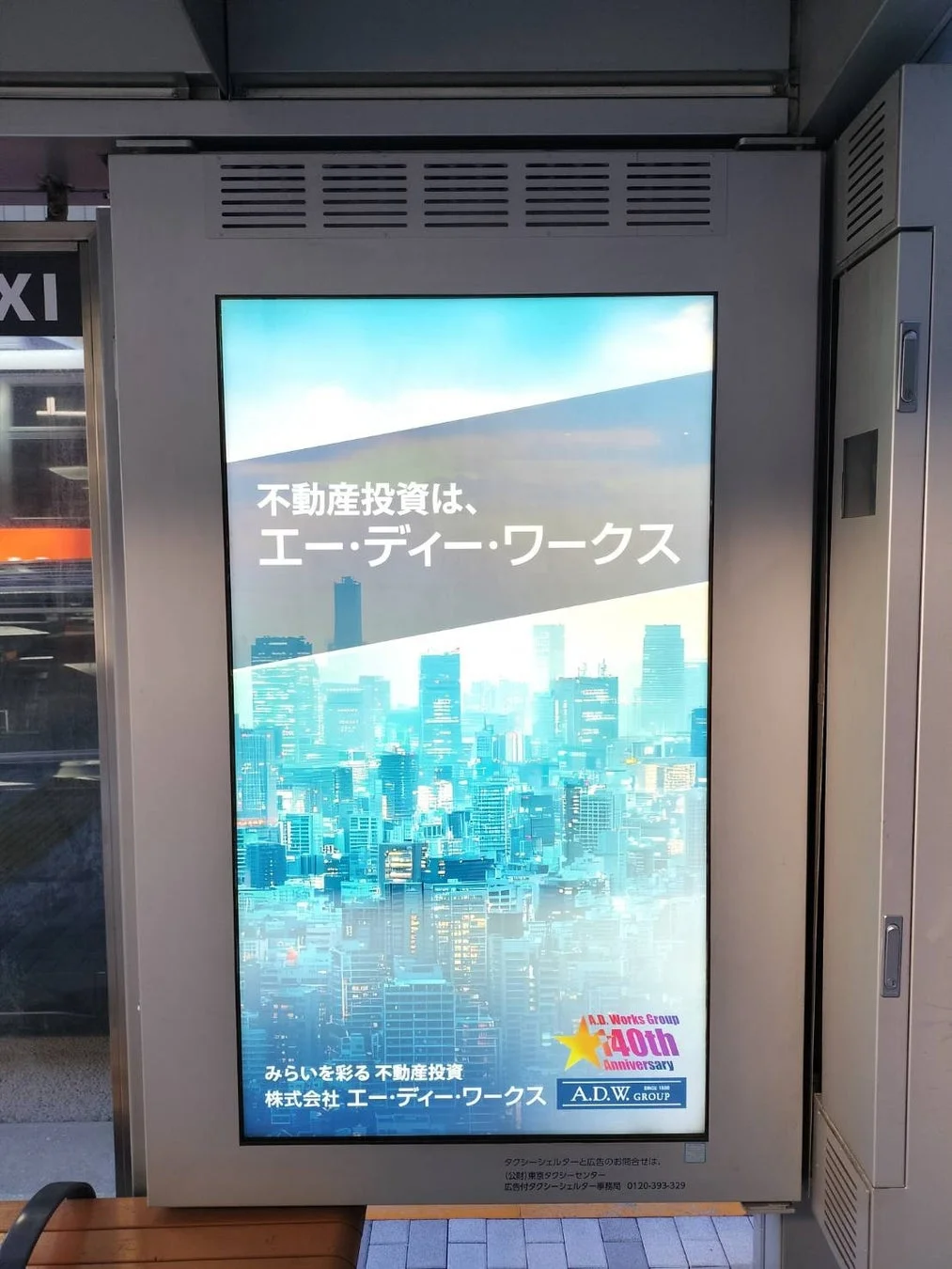 都市のビル群を背景にした不動産投資会社のデジタル広告。エー・ディー・ワークスが40周年を迎え、「みらいを彩る不動産投資」を掲げている。