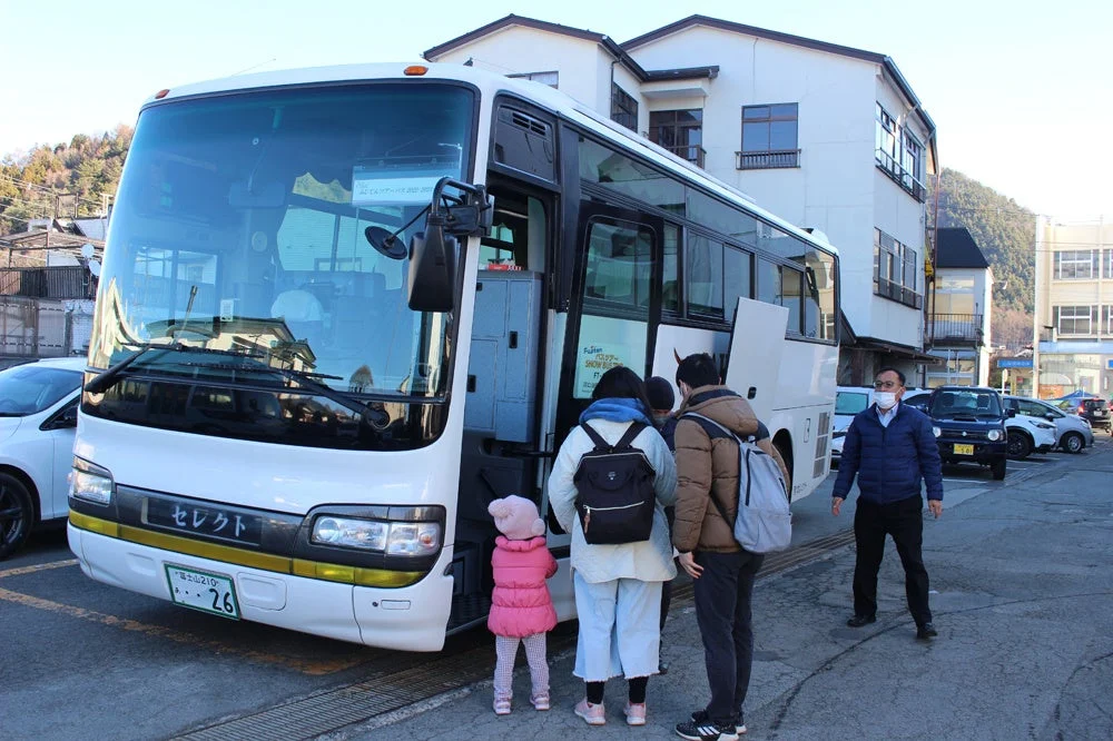バスの前に立つ家族