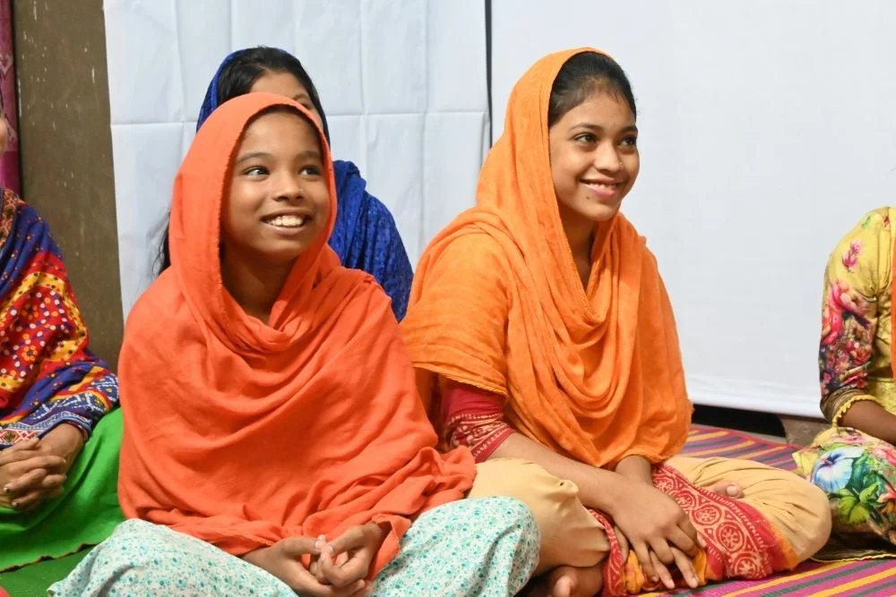 笑顔で床に座る2人の少女