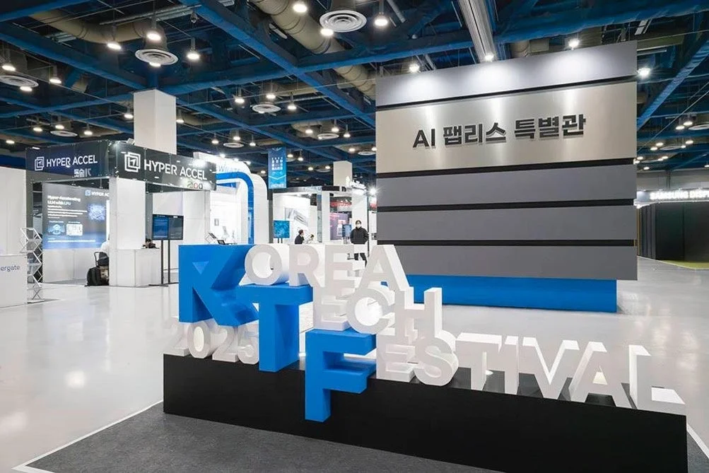 広々とした展示会場の様子。KOREA TECH FESTIVAL 2023の大きなロゴと、AI関連の特別館やHYPER ACCELのブースが見える。最新技術が集まる活気あるイベントの雰囲気。