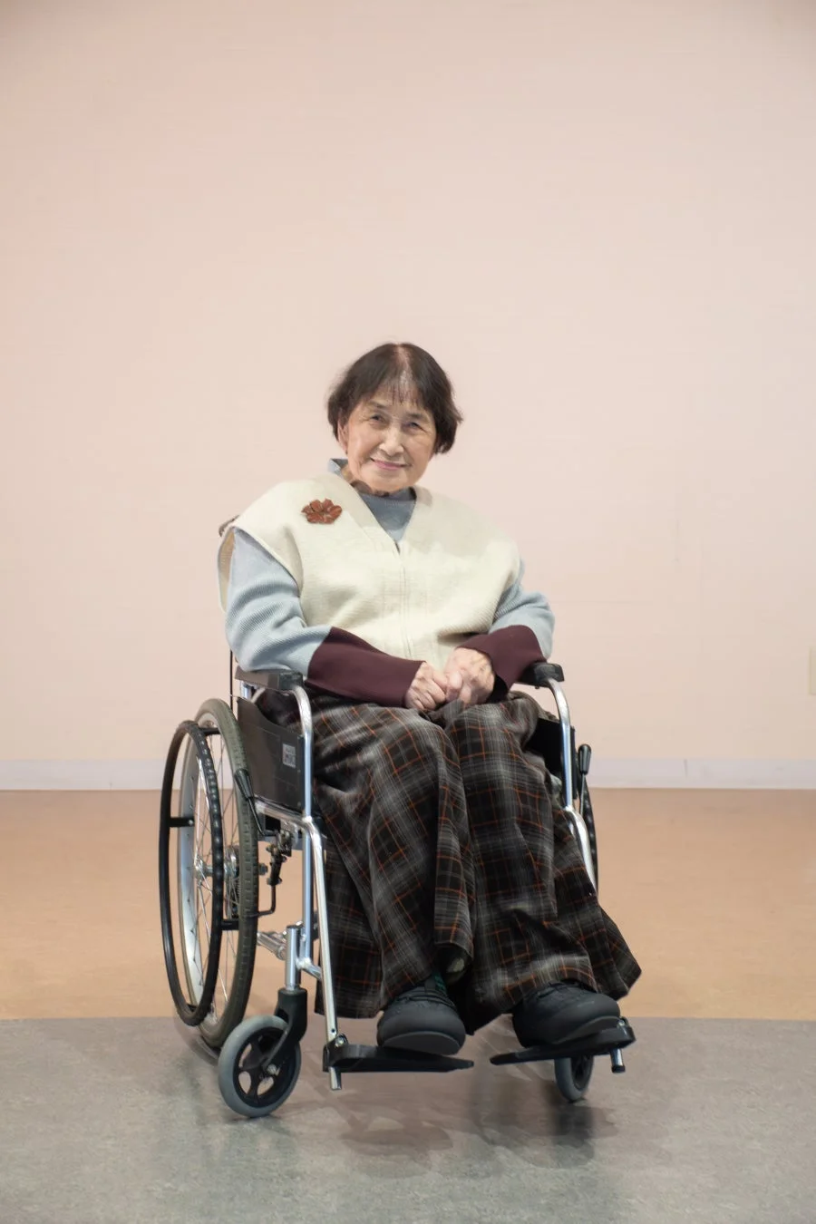 車椅子の高齢女性が笑顔でポーズ