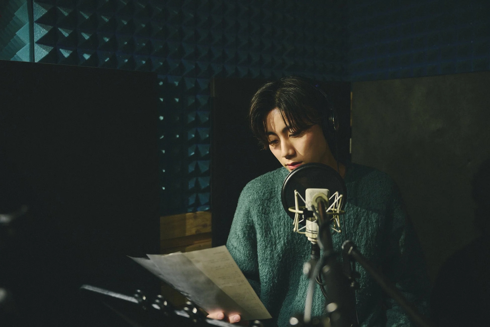 レコーディングスタジオでマイクに向かう人物