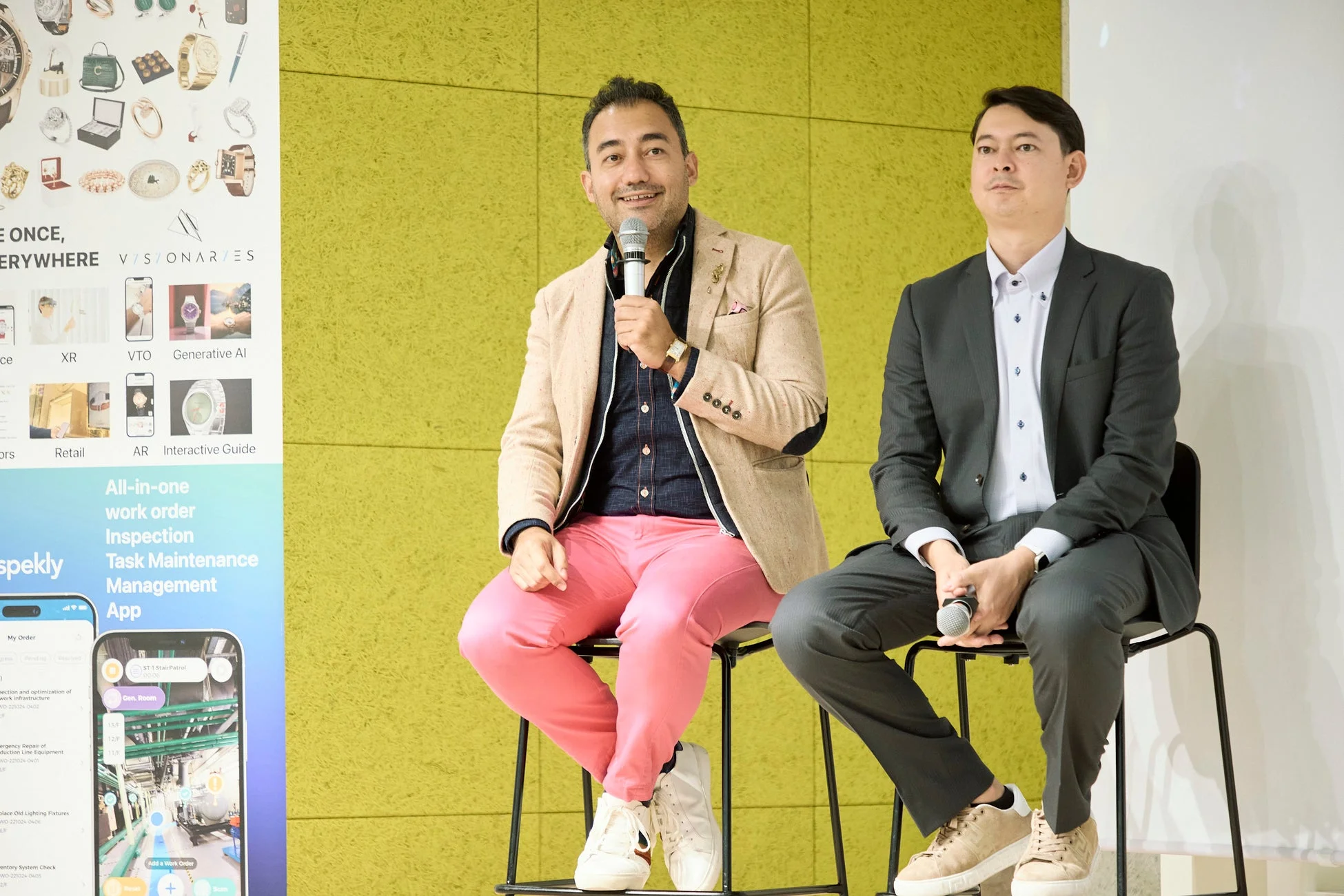 ビジネスイベントでマイクを持って座る二人の男性