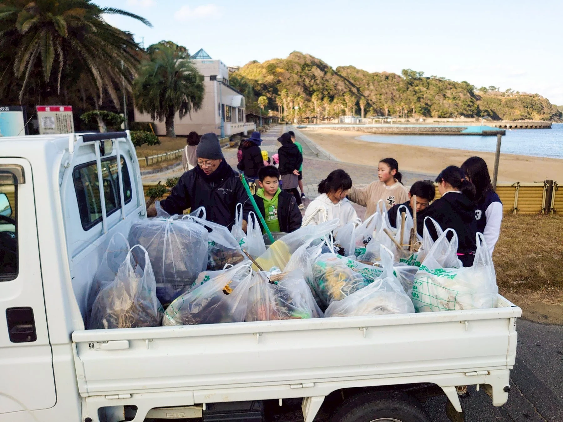子どもたちが集めたゴミを軽トラックに積み込む様子