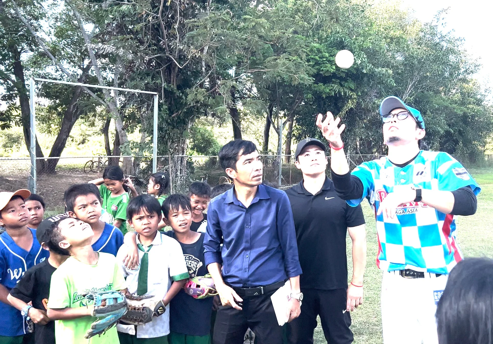 大人と子供たちが野球の練習をする様子