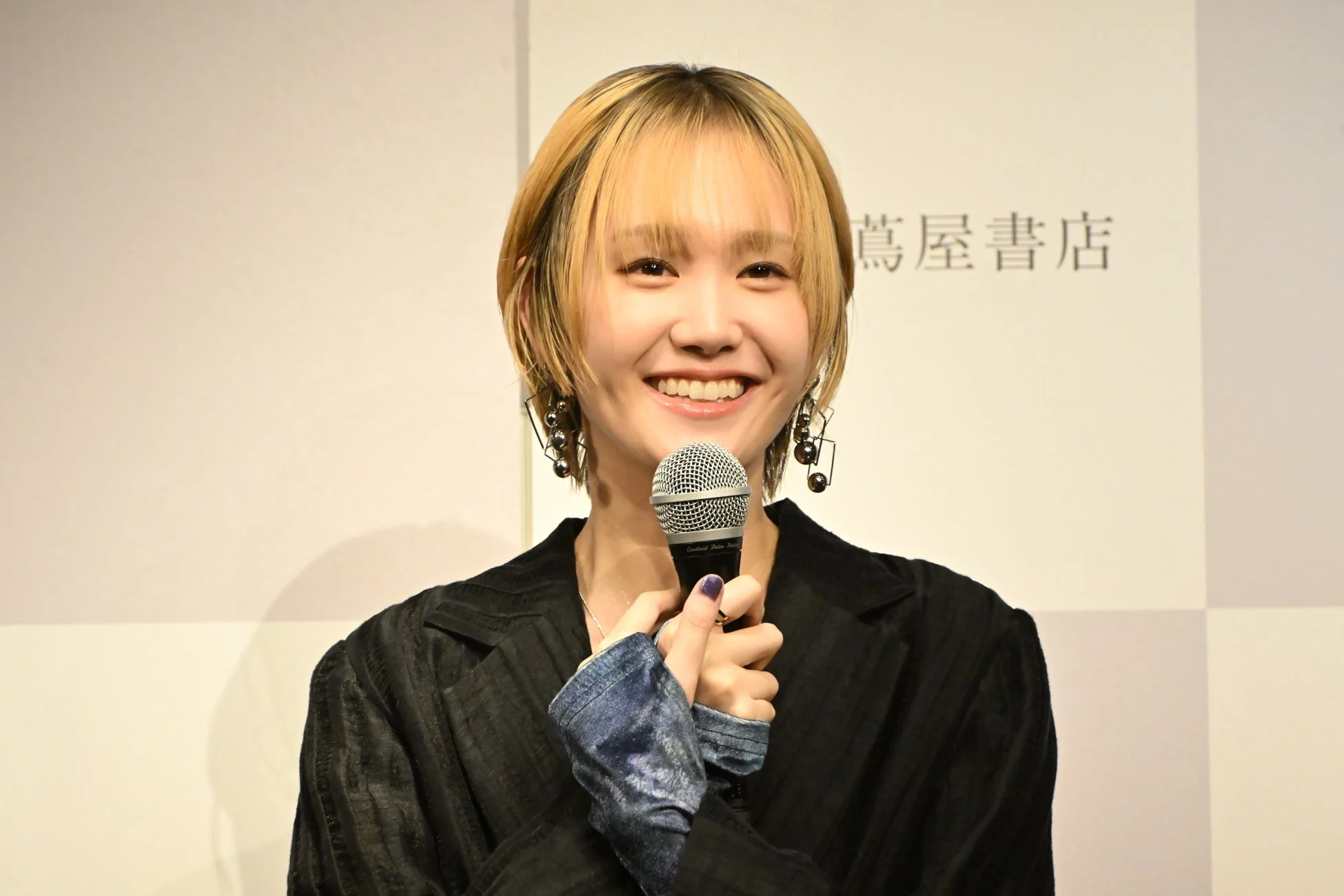 マイクを手に笑顔で話す尾碕真花