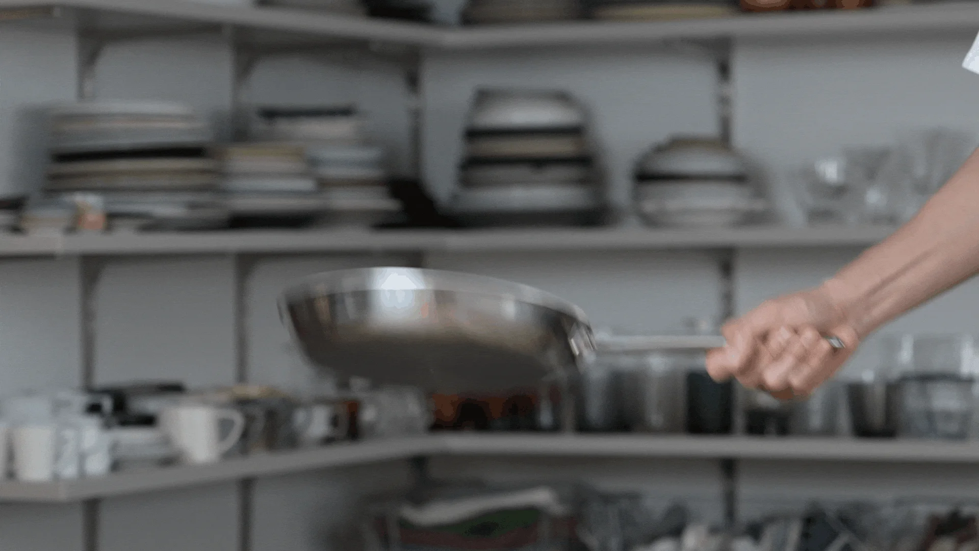 プロのキッチンでフライパンを振るシェフ