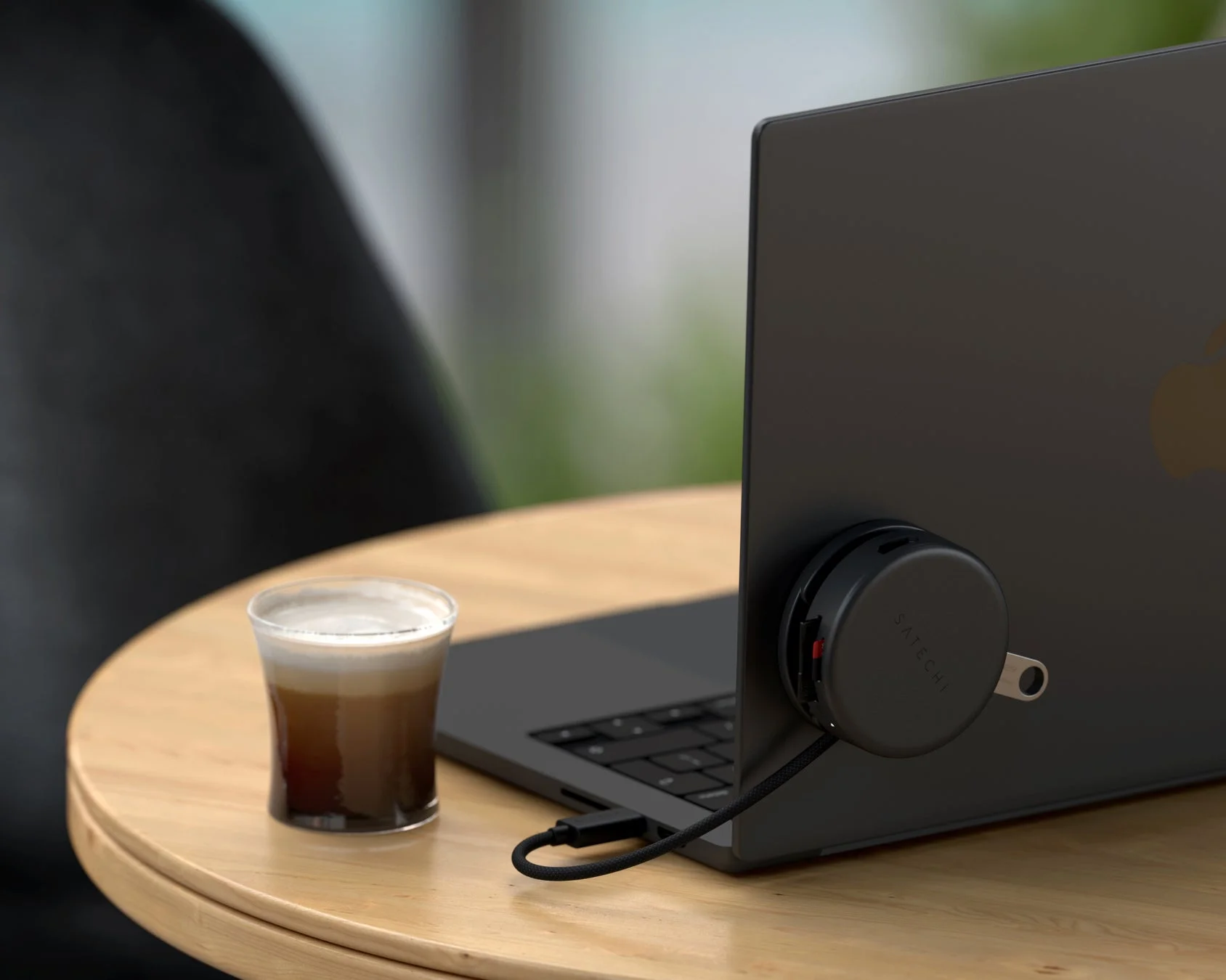 Satechi製の丸いUSBハブが接続された黒いラップトップ