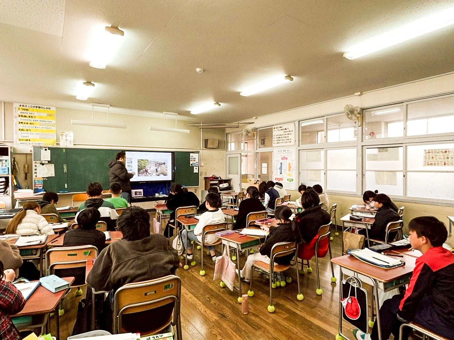 教室で大型ディスプレイを使って授業を受ける生徒たち