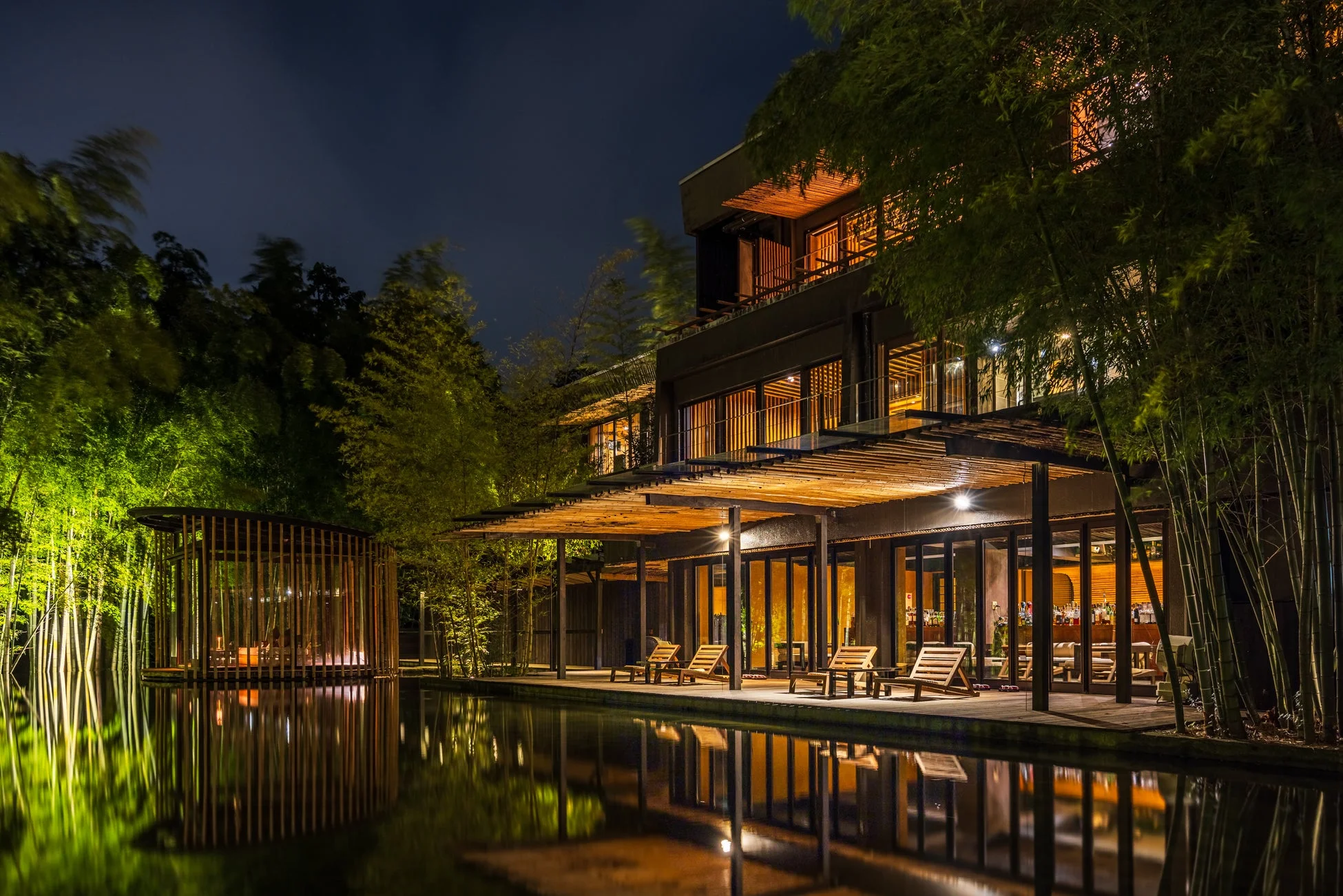 夜の竹林に囲まれたモダンな建物