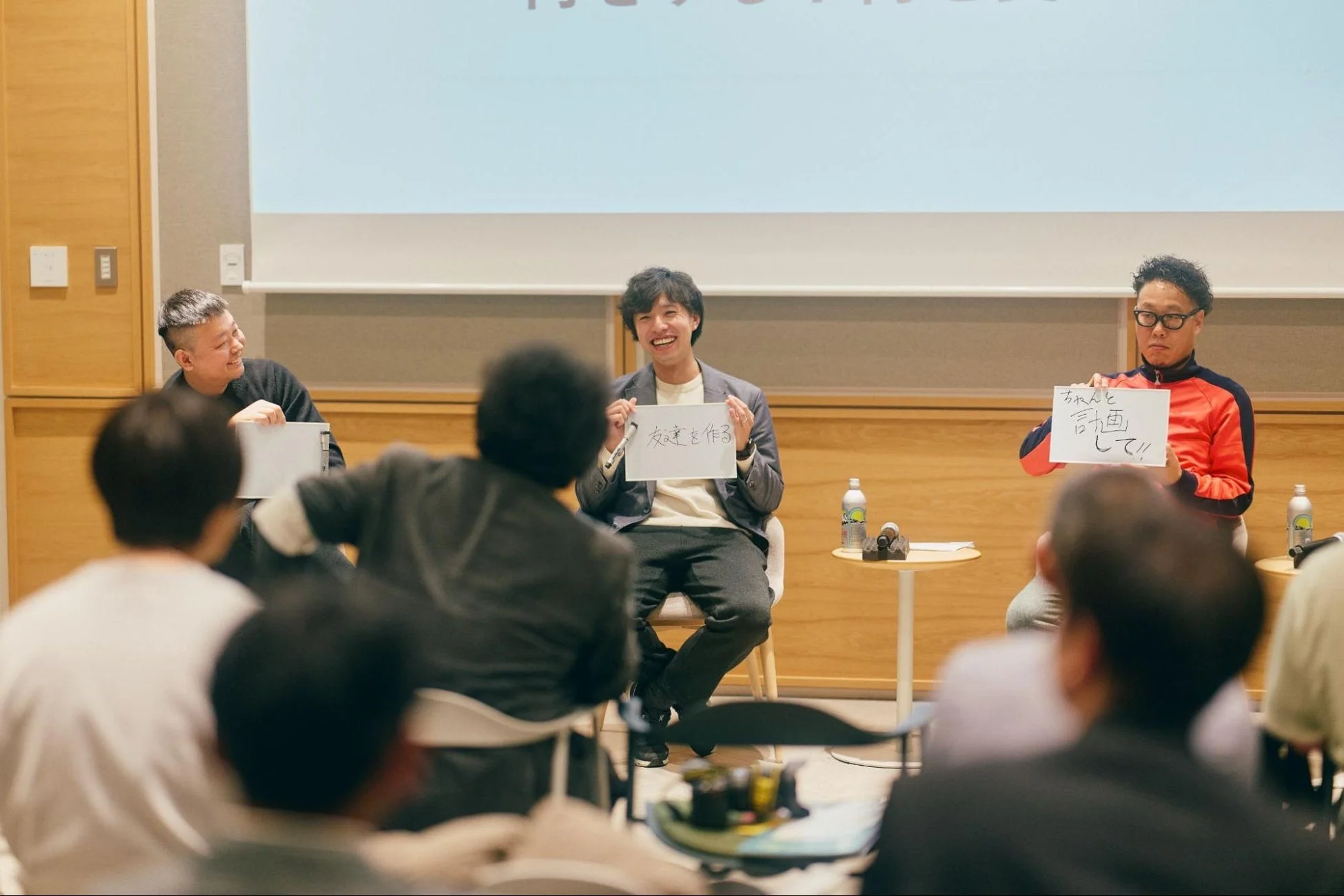 登壇者3人がフリップを持っている写真