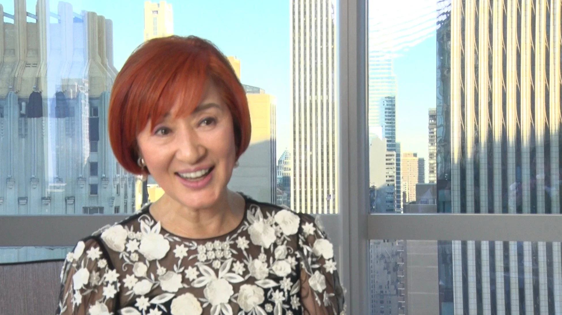 窓際で笑顔の松居一代さん