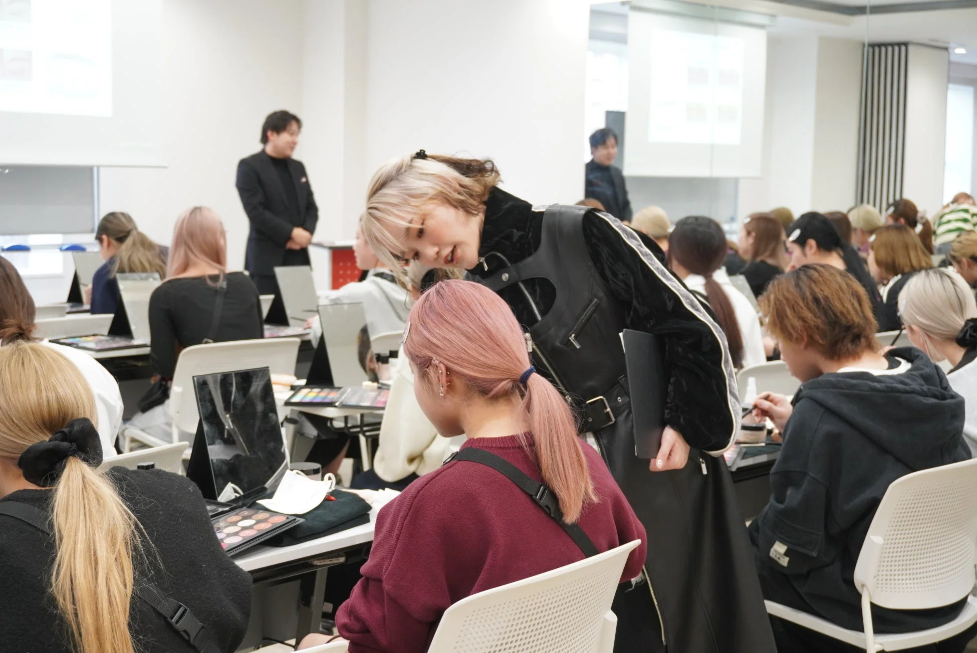 生徒たちがメイク実習に取り組んでいる様子