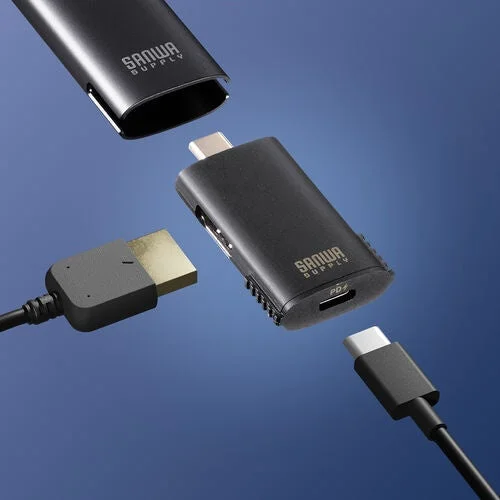 青い背景に、USB-CやHDMIポートを備えた黒い電子機器とケーブルが配置されています
