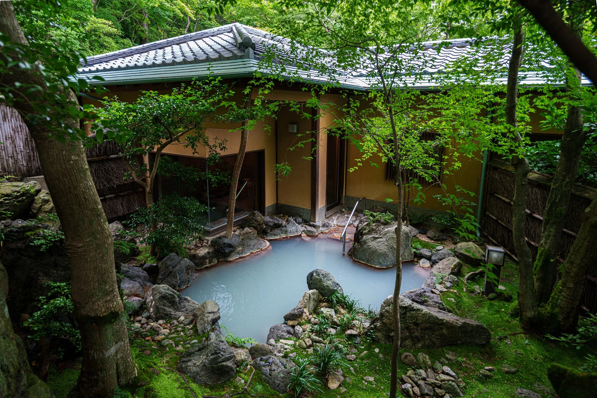 豊かな緑と苔に囲まれた日本家屋の前に広がる露天風呂