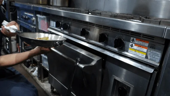 プロの厨房で料理中のシェフ