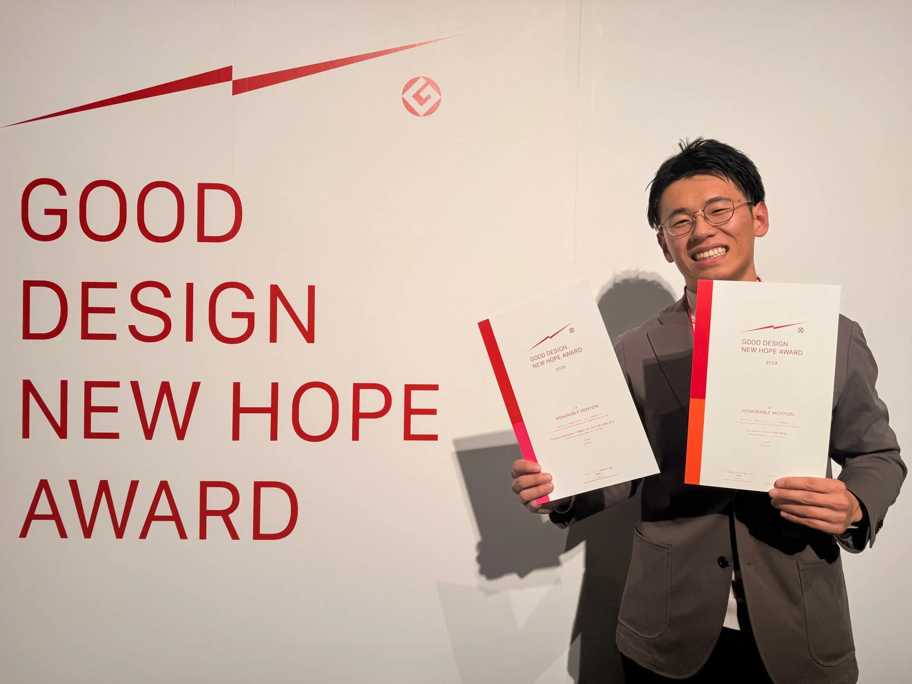 グッドデザイン・ニューホープアワードの賞状を持つ金子智紀代表