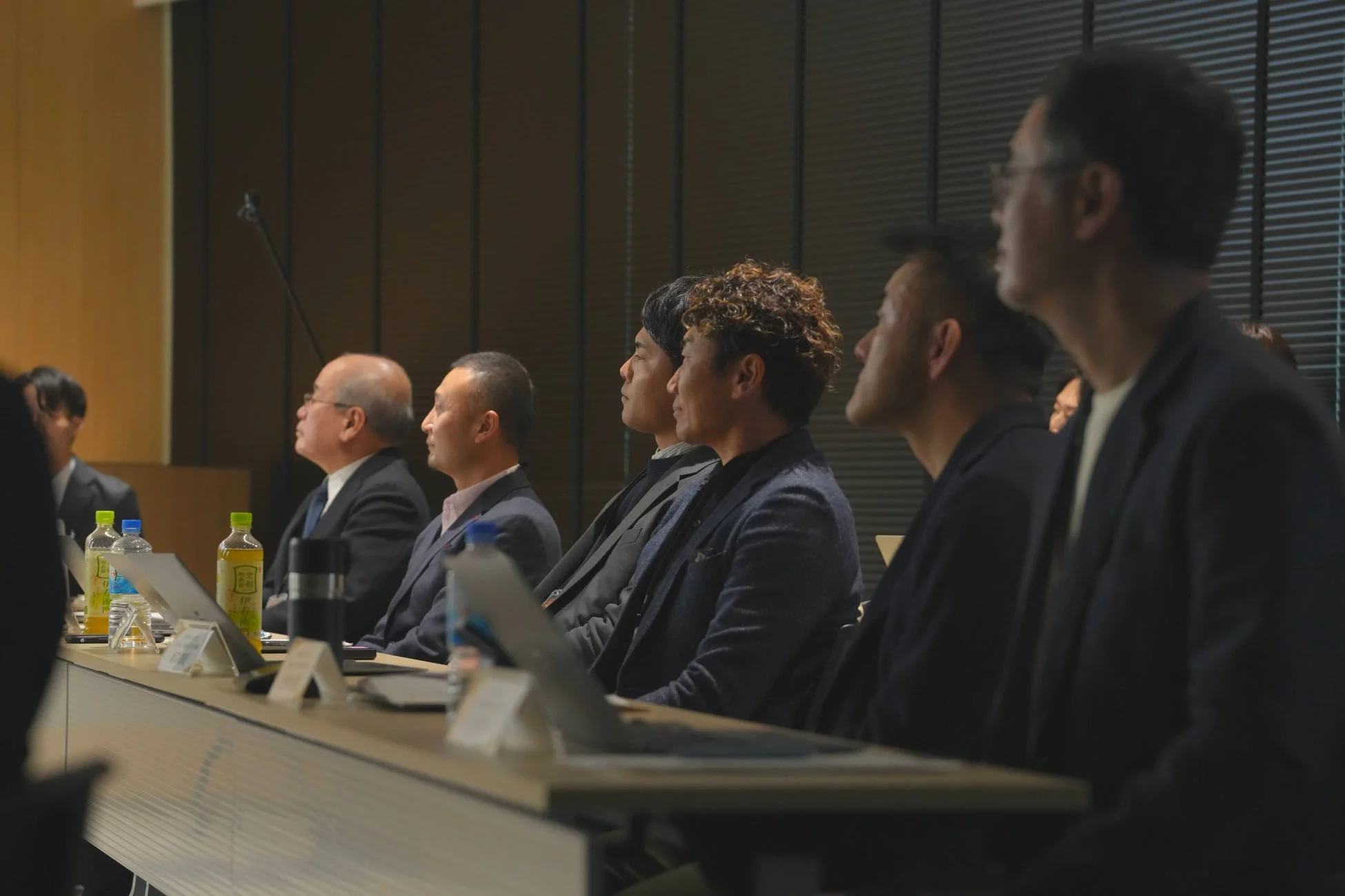 会議室で聴講するビジネスマン