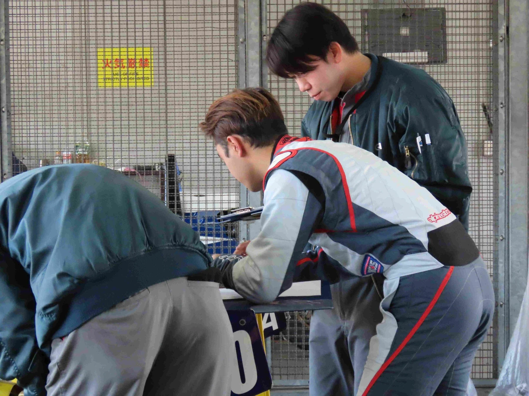 ピットエリアで打ち合わせをするチームメンバー