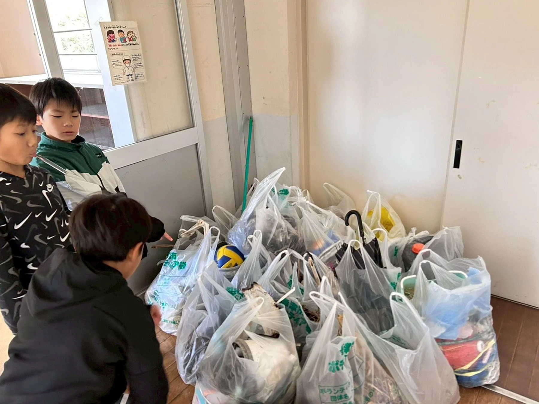 教室で集めたゴミを分別する小学生たち