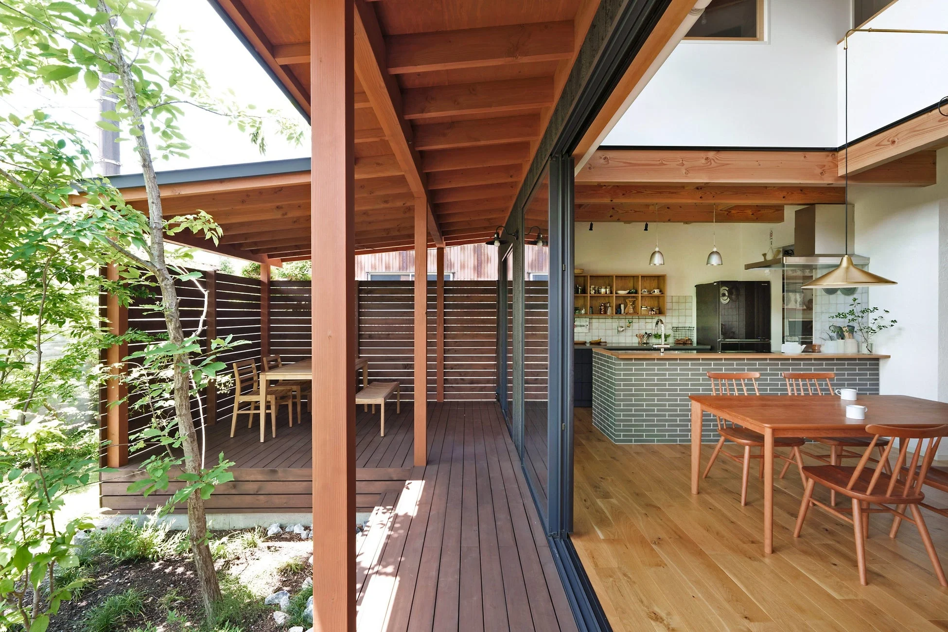 広々としたウッドデッキとオープンなLDKが一体となったモダンな住宅