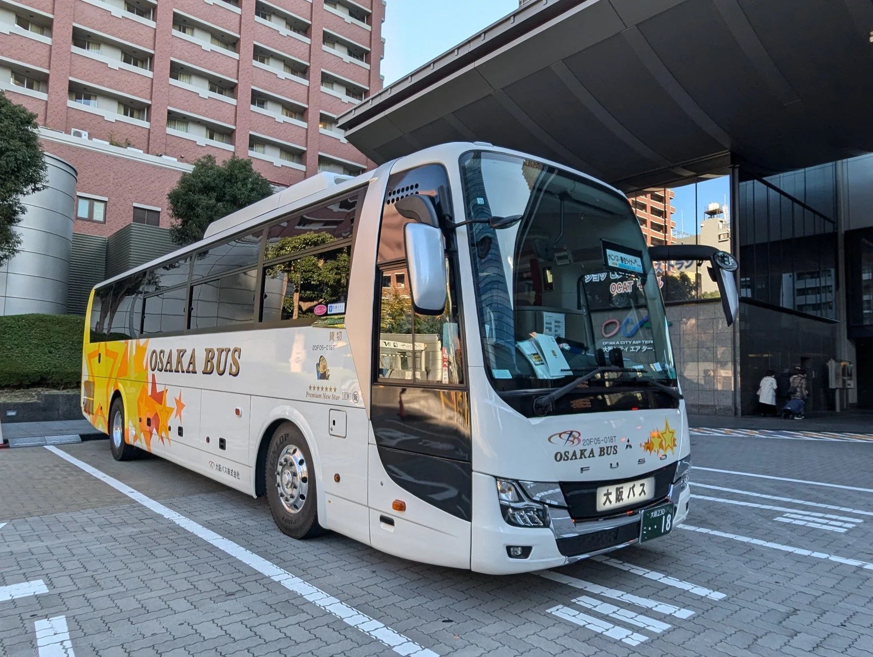 白い車体に黄色とオレンジの星がデザインされた大阪バスの貸切バス