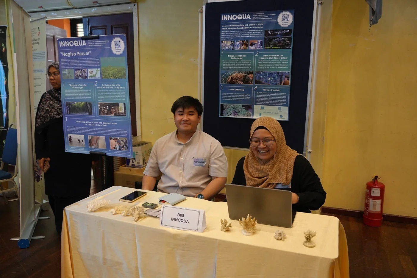 INNOQUAとNagisa Forumの展示ブースで来場者に対応する男性と女性